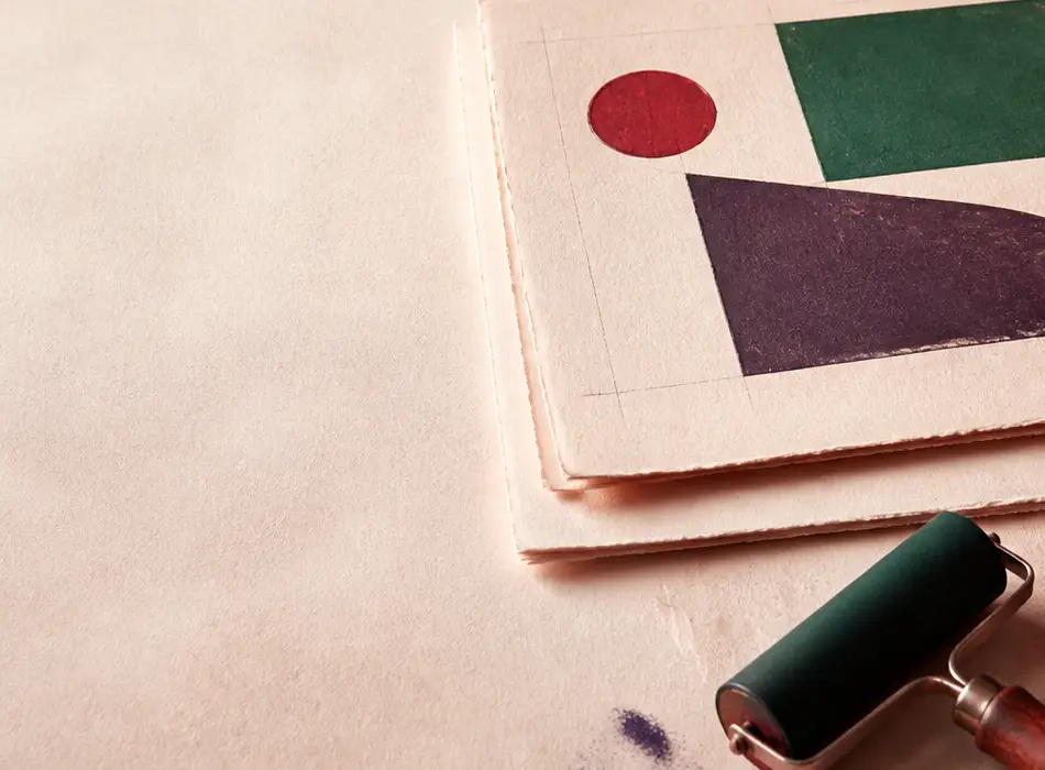 Carnet ouvert près d'un nuancier et d'un outil de reliure sur papier chaud.